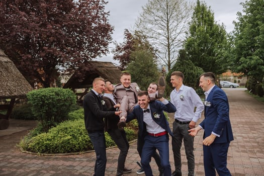 Cheerful, young, energetic witnesses of the groom next to the groom. Friends congratulate the groom. Groom and his funny friends having fun on the wedding day of the newlyweds. photo