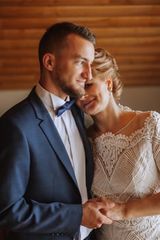mother helps her adult son prepare for the wedding ceremony. An emotional and touching moment at a wedding. A mother hugs her son photo