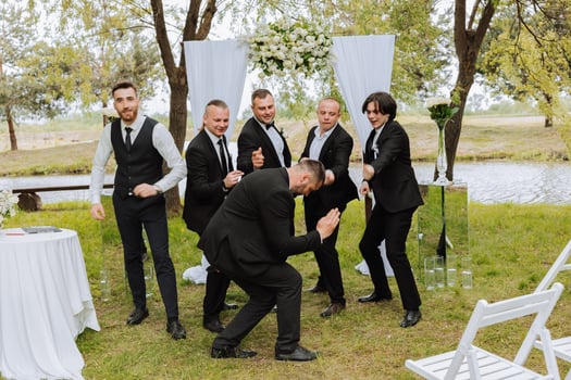 Cheerful, young, energetic witnesses of the groom next to the groom. Friends congratulate the groom. Groom and his funny friends having fun on the wedding day of the newlyweds. photo