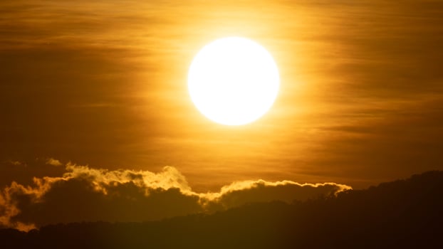 Closeup of bright big sun on the sky with orange gradient colors in a calmly evening. photo