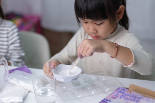 Cute little girl making DIY plaster and painting at home. Children paint on plaster sculptures with family on holiday. Imagination and creativity activities. photo
