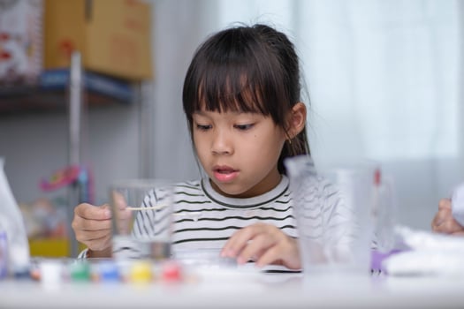 Cute little girl making DIY plaster and painting at home. Children paint on plaster sculptures with family on holiday. Imagination and creativity activities. photo