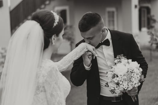 She told him yes. A young man kisses his wife's hand with a gold ring, proposing marriage. Engagement of a young couple in love. Concept of love and unity. photo
