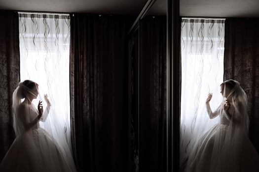 A luxurious bride with a beautiful hairstyle and a gorgeous dress is getting ready for the wedding ceremony in the morning. Morning photo of the bride at home or in a hotel room. Professional makeup.