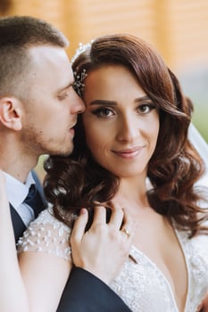 Wedding. Love and couple in garden for wedding. Celebrating the ceremony and commitment. Save the date. Trust. The groom embraces the bride. Tender kisses. Couple in love. Wedding portrait photo