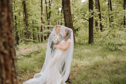 Wedding. Love and couple in garden for wedding. Celebration of ceremony and commitment. Save the date. Trust. The bride and groom embrace. The groom embraces the bride under the veil. photo