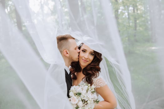 Wedding. Love and couple in garden for wedding. Celebration of ceremony and commitment. Save the date. Trust. The bride and groom embrace. The groom embraces the bride under the veil. photo