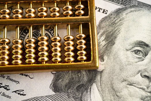 Gold abacus on US dollar banknote money, economy finance exchange trade investment concept. photo