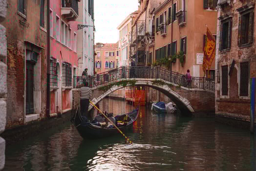 Tranquil black gondola on busy Venice canal, capturing the city's unique charm. photo