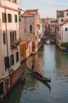 Iconic Gondola Gliding Through Serene Venice Canal - Classic Italian Waterway Scene photo