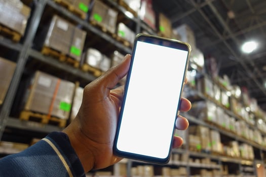 business owner holding phone mock up in warehouse. photo