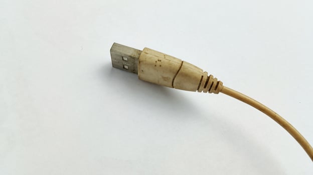 worn white usb cable on white background photo