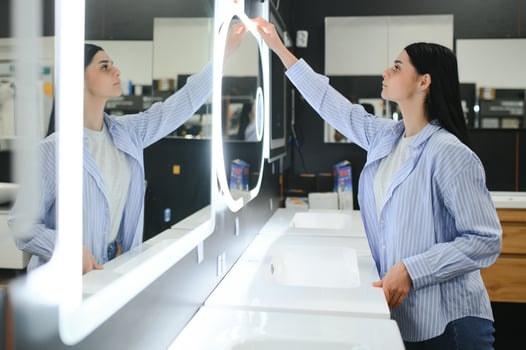 Woman chooses a mirror at home in a store photo