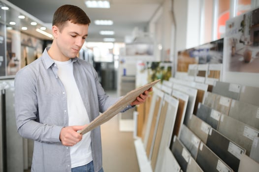 Young man choosing tiles at building market photo