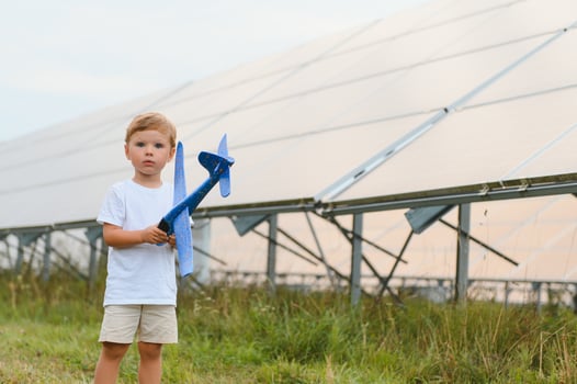 A little boy is having fun near the solar panels. The concept of solar energy. photo