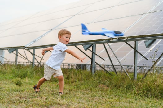 A little boy is having fun near the solar panels. The concept of solar energy. photo