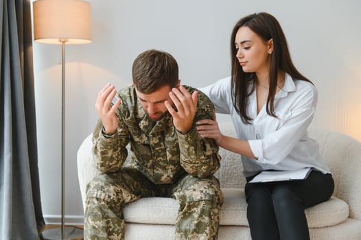 Sad male soldier on appointment with psychologist at office photo