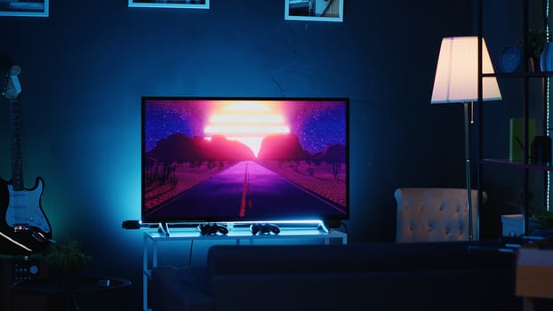 Empty stylish neon lit home studio interior illuminated with neon lights at night and artwork decorating the walls. Modern apartment with TV running in background on news channel broadcast photo