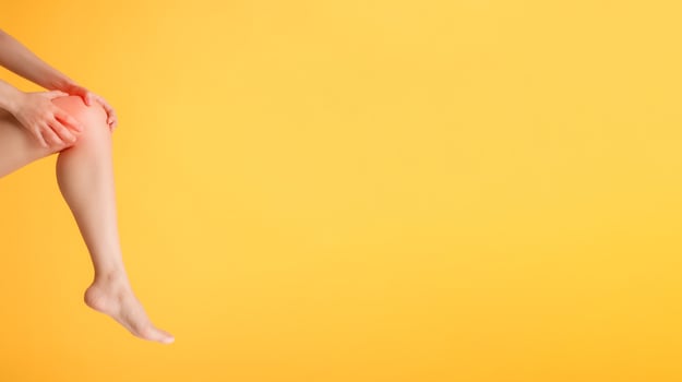 Discover knee pain relief and legs healthcare with woman's hands holding her painful knee on a vibrant yellow background. photo