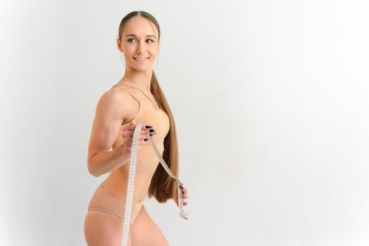 Woman measuring her slim body isolated on white background. photo