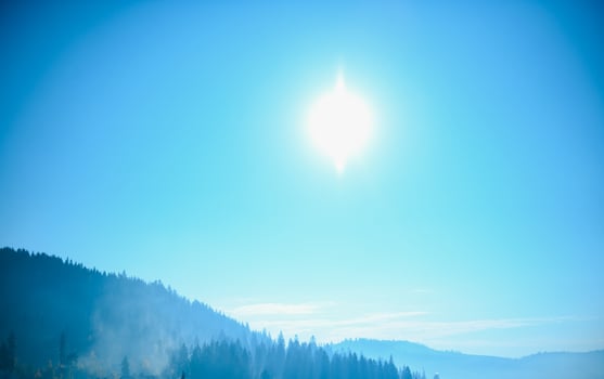 Mountain range with visible silhouettes through the morning blue fog. photo
