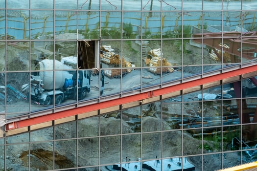 industrial background - a mirror wall of an unfinished building, which reflects the construction site photo