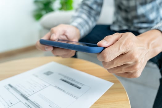 business man use phone to scan barcode or QR codes to pay credit card bill after receiving document invoice online. payment, receive, paying electricity, digital payments without money, technology photo
