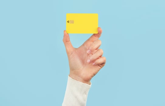 A female hand holds a payment card on a blue background. Bank card layout. photo