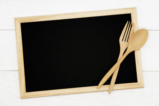 Blank chalkboard with wooden spoon and fork on white wood plank background. Styled stock photography for cookbook, food blog posts and social media content. photo