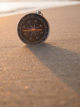 Close up compass on the beach with sunlight photo