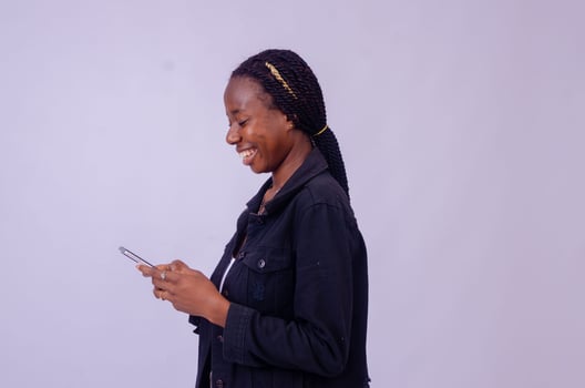 young black woman using her phone looking surprised photo