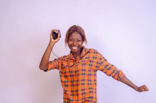 overjoyed young black woman using her phone looking amazed photo