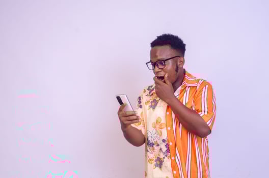 Cheerful African American man in white shirt using mobile phone application. photo