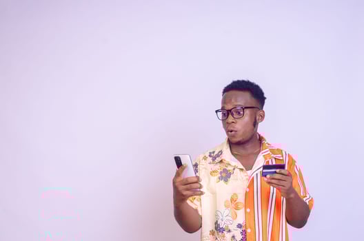 excited african man excited smiling as he makes payment with his card photo
