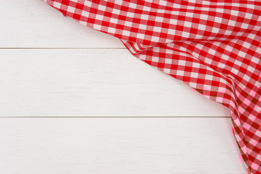 Wrinkled red gingham fabric on rustic white wood plank background, with copy space. photo