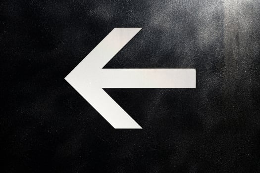 White Arrow on Black Metal Sign Background. photo