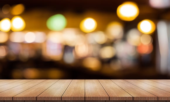 Empty wooden table top with lights bokeh on blur restaurant background. photo
