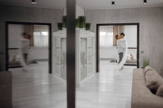 Happy bride and groom in a hotel room in the morning. Brides in love. A confident girl is a bride in the arms of the groom. Preparation for the wedding. Reflection in the mirror photo