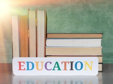 textbooks on desk in front of blurred blackboard photo