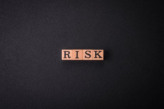 The inscription Risk made of wooden cubes on a plain background photo