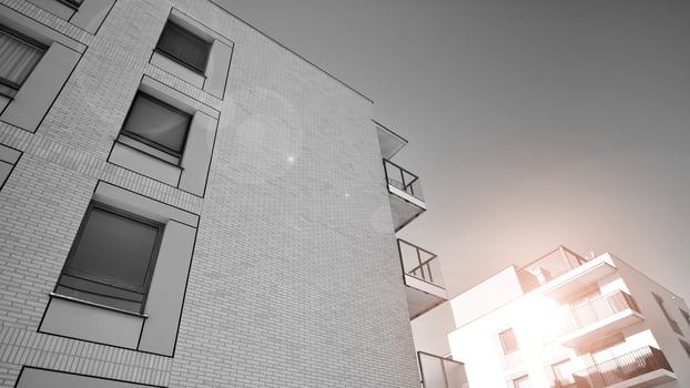 Fragment of the building's facade with windows and balconies. Modern apartment buildings on a sunny day. Facade of a modern residential building. Black and white. photo