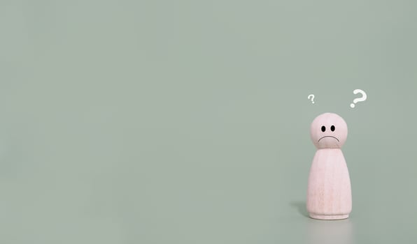 Wooden human figure with question marks. The concept of question or answer time. photo