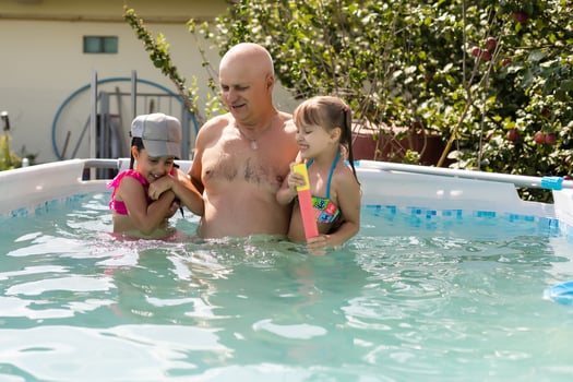 Portrait of a happy grandfather with grandchildren in pool photo