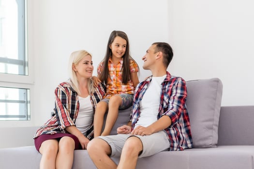 Smiling young parents and their child are very happy, they are at home photo