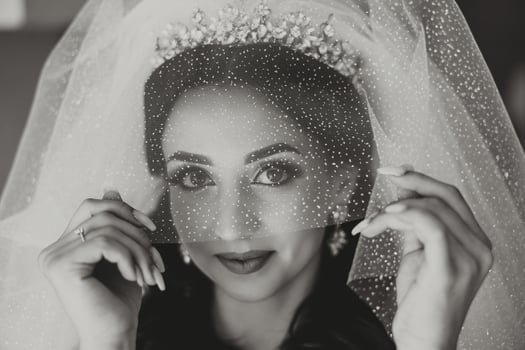 Beautiful young bride holding veil in white wedding dress, portrait of brunette bride in hotel room, morning before wedding. photo