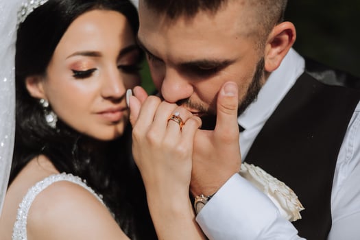 Wedding kiss. Groom kisses bride's hand. Weddng love. Close-up of a young man kissing his wife's hand with gold ring while making a marriage proposal. photo