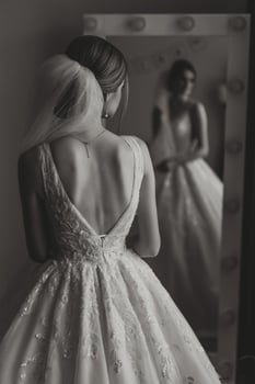 Portrait of the bride in the hotel room. A beautiful young girl is dressed in a white wedding dress. Modern wedding hairstyle. Natural makeup. photo