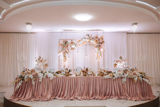 Restaurant wedding table for bride and groom. luxury wedding table with beautiful flowers. pink stylized photo