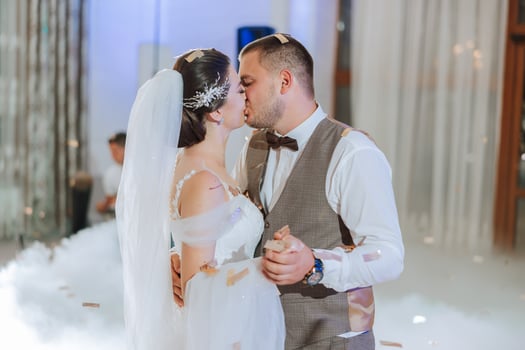 Wedding dance of the bride and groom. The first dance of the bride and groom in an elegant wedding hall with the use of heavy smoke and pyrotechnic lights, confetti. photo