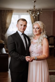 mother helps her adult son prepare for the wedding ceremony. An emotional and touching moment at a wedding. A mother hugs her son photo